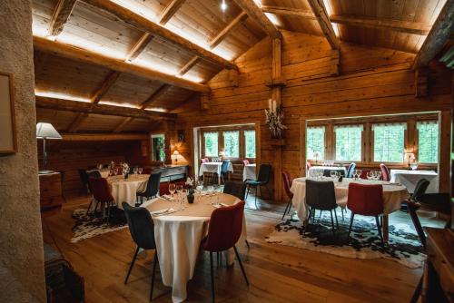 un restaurante con mesas y sillas en una sala con paredes de madera en Les Chalets de la Serraz en La Clusaz