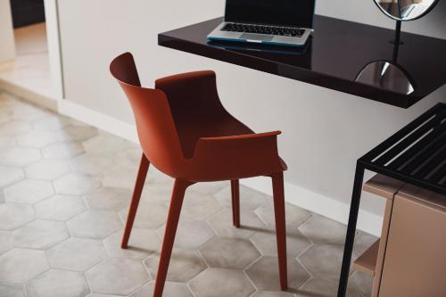 a orange chair sitting at a desk with a laptop at Volante Urban Design Hotel in Santeramo in Colle