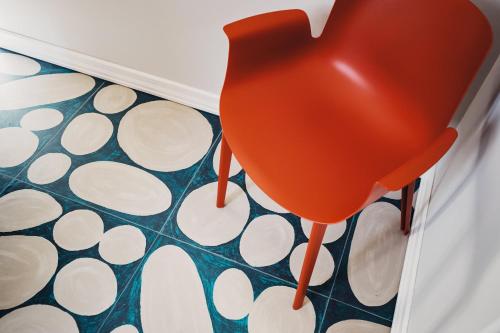 a red chair sitting on a floor in a room at Volante Urban Design Hotel in Santeramo in Colle