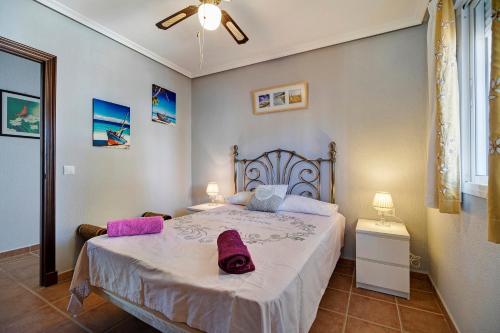 Un dormitorio con una cama grande con almohadas moradas. en Casa Adela, en Chiclana de la Frontera