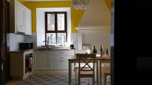 cocina con paredes amarillas, mesa y ventana en The Green Lake House, en Lenna