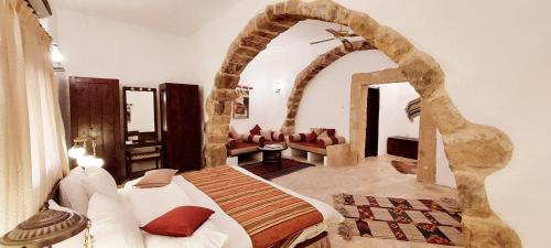 Hayat Zaman Hotel And Resort Petra في وادي موسى: غرفة نوم بسرير في غرفة بها قوس
