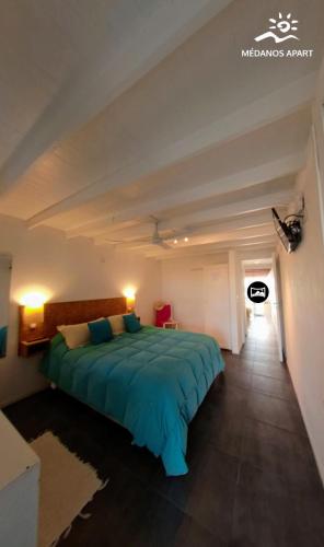 a bedroom with a large green bed in a room at Medanos in Las Gaviotas