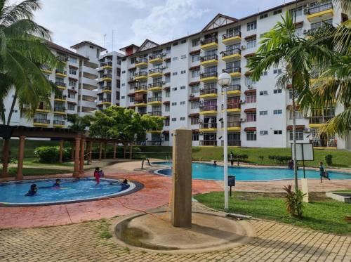 ein großes Apartmenthaus mit einem Pool und Palmen in der Unterkunft Laguna Condo Resort Port Dickson in Port Dickson