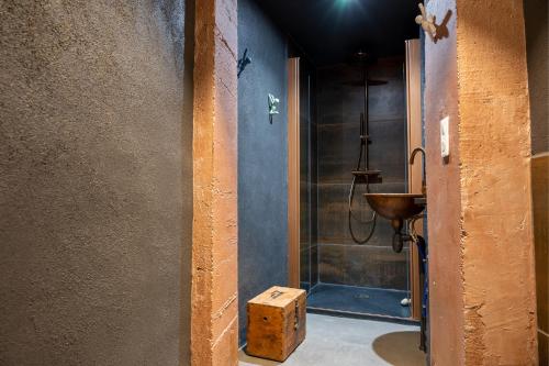 baño con ducha y lavabo con caja de madera. en B&B Bacchus Grotto with only 1 suite 45m2 plunge pool privé en Cairanne