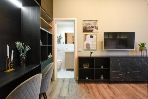 a living room with a tv and a black counter at MONOCHROME MAGIC. Calea Victoriei Studio in Bucharest