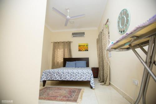 a bedroom with a bed and a ceiling fan at Aviation Highway Apartment in Spintex