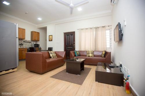 a living room with two couches and a tv at Aviation Highway Apartment in Spintex