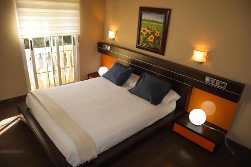 a bedroom with a bed and two lamps and a window at Hotel Las Navas in Malagón