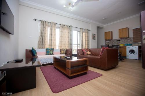 a living room with a couch and a table at Aviation Highway Apartment in Spintex