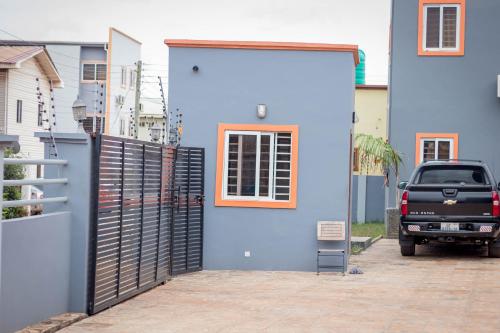 a blue building with a black gate and a truck at Aviation Highway Apartment in Spintex