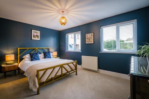 a bedroom with blue walls and a bed with blue pillows at Rockside - Luxury 1 bedroom home with hot tub central, parking pet friendly hot tub turns off 930pm in Windermere