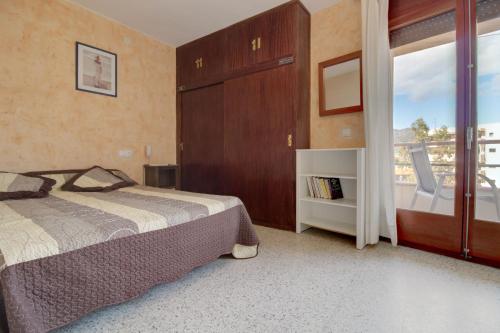 a bedroom with a bed and a large window at Global Immo 2133 Hort de Mar in Roses