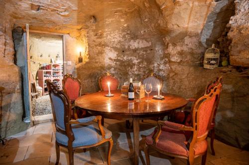 uma sala de jantar com uma mesa de madeira e cadeiras em B&B Bacchus Grotto with only 1 suite 45m2 plunge pool privé em Cairanne