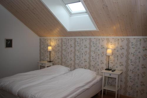 a bedroom with a bed and two tables with lamps at Hotel Stallbacken Nagu in Nauvo