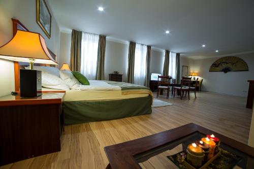 カルロヴィ・ヴァリにあるApartmány Amethystのベッドとリビングルームが備わるホテルルームです。