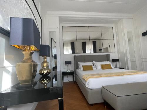 een slaapkamer met een bed en een tafel met een lamp bij Calzaiuoli3 Luxury Flat in the City Center of Florence in Florence