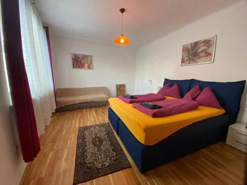 um quarto com uma cama com almofadas coloridas em Apartment Domino em Viena