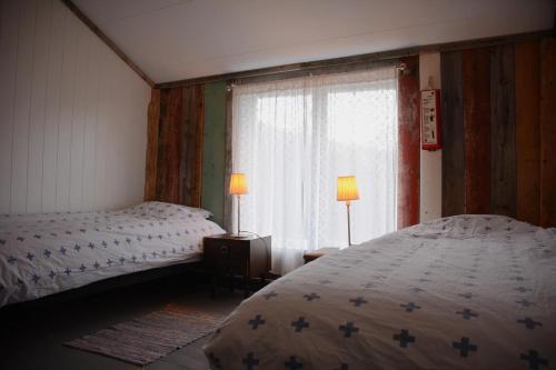a bedroom with two beds and a window at Villa Vengetind in Isfjorden