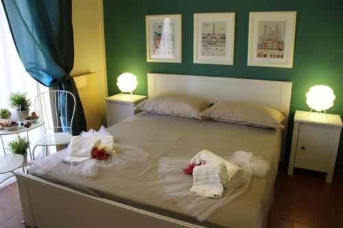 a bedroom with a large bed with two white towels at Retrò Rooms in Cefalù