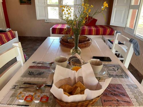 einen Tisch mit einem Korb Brot und Tassen darauf in der Unterkunft Cabaña Chañares de Banda Florida - Ama in Villa Unión