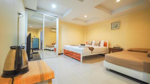 a bedroom with two beds and a mirror at Joy House Jomtien Beach in Jomtien Beach