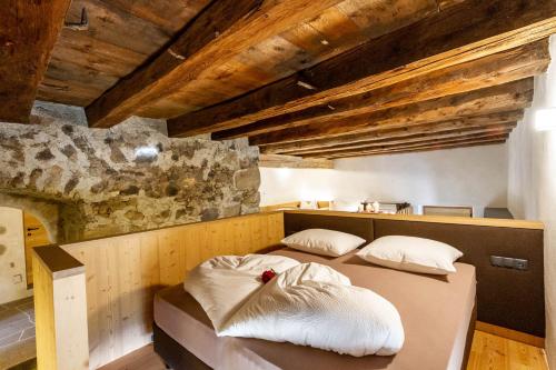 two beds in a room with wooden ceilings at Daimlhof Ferienwohnung Schlernstein in Völs am Schlern