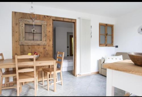 una cucina e una sala da pranzo con tavolo e sedie in legno di CASA CARCENTINA a Bormio