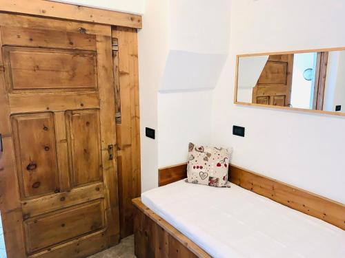 una camera con una porta in legno e una panca di CASA CARCENTINA a Bormio