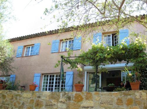 Casa con ventanas azules y pared de piedra en Chambre avec acces jardin et piscine. Weekend ou semaine., en Le Rouret