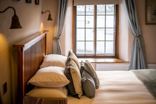 a bedroom with a bed with pillows and a window at Luxury 1 bed Villa - great location - Peaceful-Hot Tub in Bowness-on-Windermere