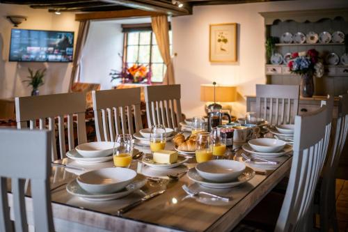 a dining room table with plates and glasses of orange juice at Luxury 1 bed Villa - great location - Peaceful-Hot Tub in Bowness-on-Windermere