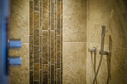 a shower stall with a hose in a bathroom at Luxury 1 bed Villa - great location - Peaceful-Hot Tub in Bowness-on-Windermere