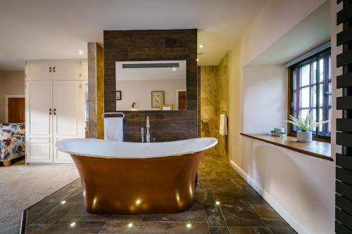 a large bathroom with a tub and a mirror at Luxury 1 bed Villa - great location - Peaceful-Hot Tub in Bowness-on-Windermere