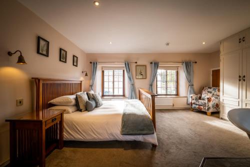 a bedroom with a bed and a chair at Luxury 1 bed Villa - great location - Peaceful-Hot Tub in Bowness-on-Windermere