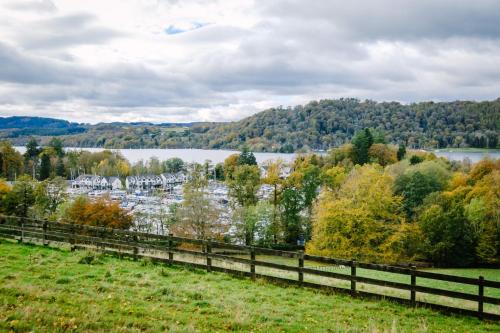 a view of a lake from a fence at Luxury 1 bed Villa - great location - Peaceful-Hot Tub in Bowness-on-Windermere