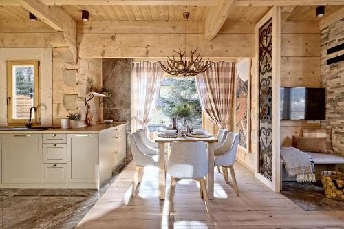 a kitchen with a table and chairs and a dining room at Osada Bachledzki Wierch Odkryj Zakopane in Zakopane