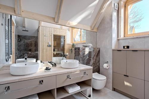 a bathroom with two sinks and a toilet at Osada Bachledzki Wierch Odkryj Zakopane in Zakopane