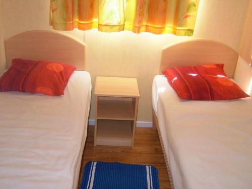 a room with two beds and a small table at Charmant bungalow à Saint-Pierre-d'Oléron - Jardin privé in Saint-Pierre-dʼOléron