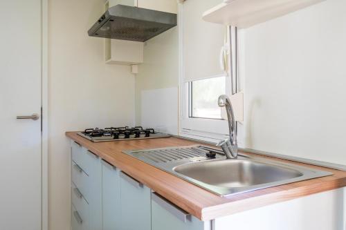 a small kitchen with a sink and a window at Villaggio Camping Odissea in Marina di Camerota