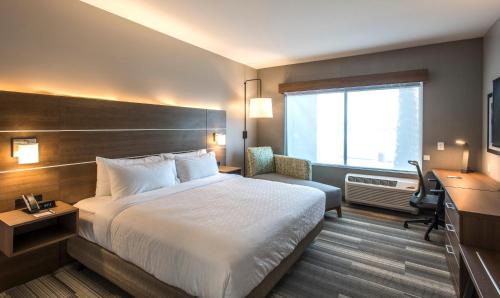 a hotel room with a bed and a desk and a window at Holiday Inn Express & Suites - Phoenix North - Happy Valley, an IHG Hotel in Phoenix