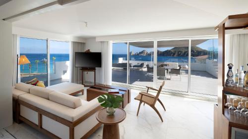 a living room with a couch and a view of the ocean at ME Cabo by Meliá in Cabo San Lucas