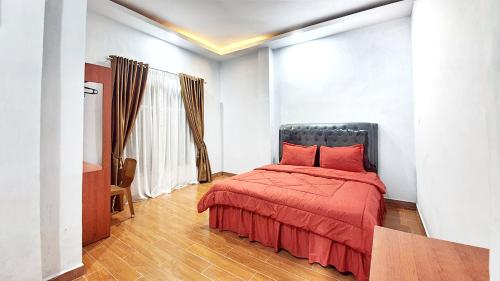 a bedroom with a bed with a red blanket at Depik Inn in Takengon