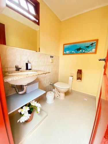 un bagno con lavandino e WC di Incrivel casa a 65m da praia do Meaipe a Guarapari
