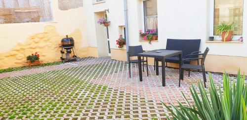 a patio with a table and chairs and a grill at Pension Schmatka Matka in Lutherstadt Eisleben