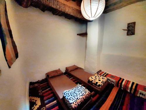 pokój z dwoma łóżkami w pokoju z dywanem w obiekcie Dar rawi w mieście Taghit