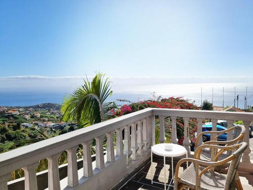 a balcony with chairs and a table and a view at Villa Alto Boutique Hotel in Ponta do Sol