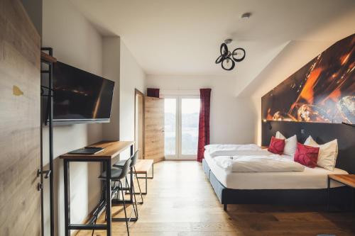 Pokój hotelowy z łóżkiem i biurkiem w obiekcie das MEISTER w mieście Riegersburg
