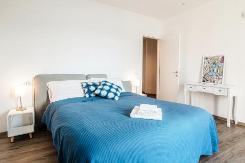 um quarto com uma cama azul e um cobertor azul em An armchair on the Lake - Private parking for medium car em Blevio