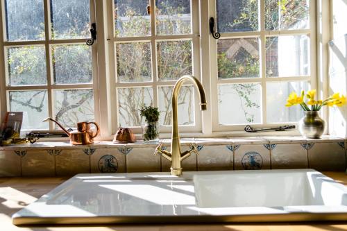 a kitchen counter with a sink and windows at The House with Two Front Doors in Rye